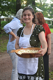 woman holding wooden bowl of popcorn